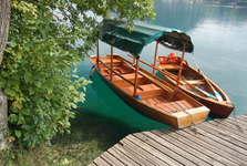 krásně čistá voda a loďky na přepravu turistů na jezeře Bled